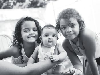 Portrait of smiling girls sitting outdoors