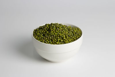 Close-up of green beans in bowl against white background