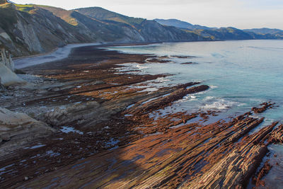 Scenic view of sea and mountains against sky