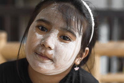 Close-up portrait of cute girl with powder on face
