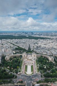 Aerial view of cityscape against cloudy sky