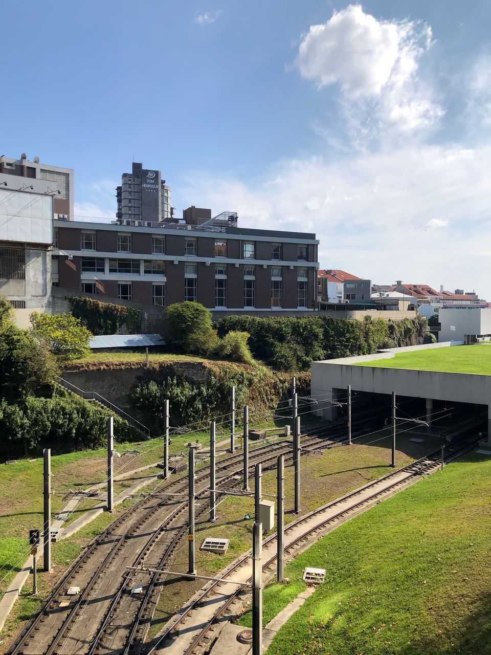 RAILROAD TRACK BY BUILDINGS AGAINST SKY