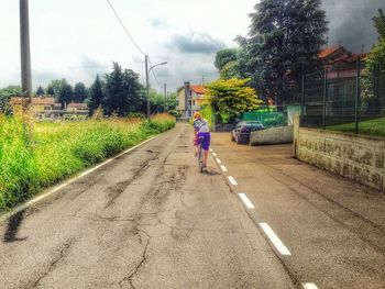 Rear view of person walking on road