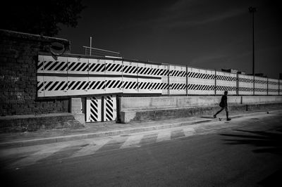 Rear view of man walking on road against sky