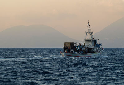 Fishing boat in sea with mountain in background