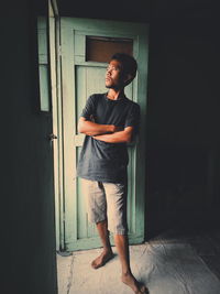 Young man standing at entrance of house