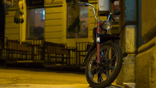 Bicycle parked against yellow wall