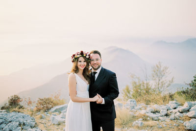 Portrait of smiling couple standing against sky