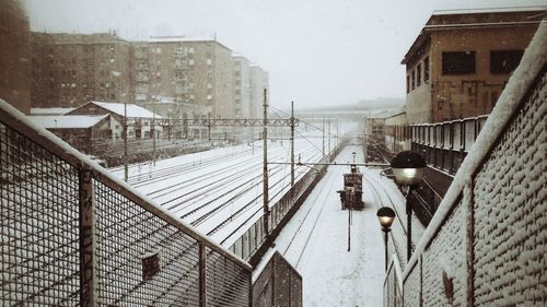 Snow covered houses against sky in city