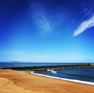 Scenic view of beach against blue sky