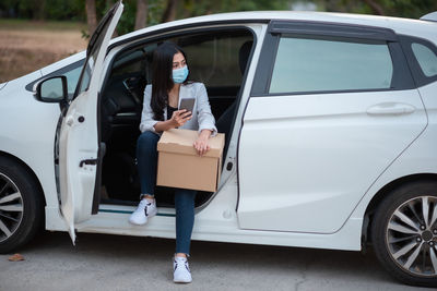 Full length of woman standing by car