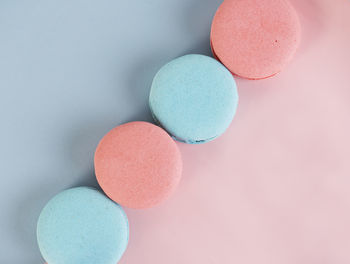 Delicious colorful french cookies macaroons on pink and blue background. top view. selective focus.