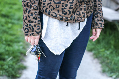 Midsection of woman holding keys while standing outdoors