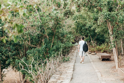 Rear view of man walking on road