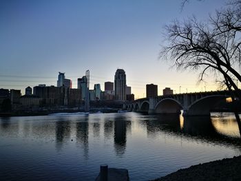 Bridge over river in city against clear sky