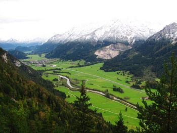 Scenic view of green landscape and mountains against sky