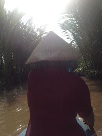 Rear view of woman standing by trees