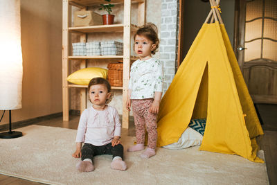 Full length of mother and girl sitting in corridor