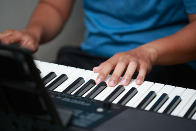 Midsection of man playing piano