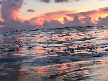 Scenic view of sea against dramatic sky during sunset