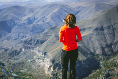 Rear view of woman standing against mountains