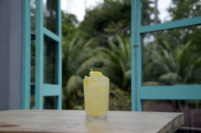 Close-up of fresh juice on table against tree