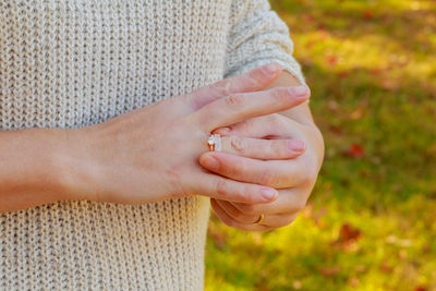 Midsection of woman wearing ring on field
