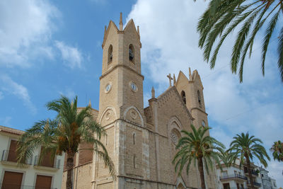 Low angle view of palm trees and buildings against sky