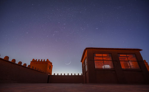 Low angle view of building against clear sky at night