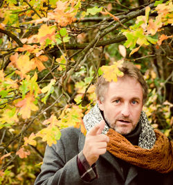 Portrait of senior man standing in park during autumn