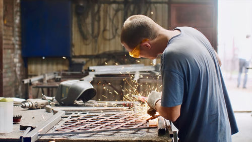 Side view of man welding in workshop