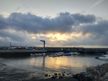 Bridge over river against sky at sunset