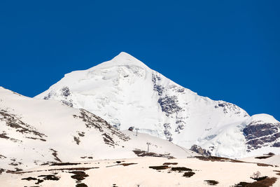 Scenic view of snowcapped mountains against clear blue sky