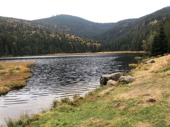 Scenic view of lake by mountains against sky