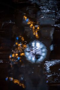 High angle view of raindrops on water at night