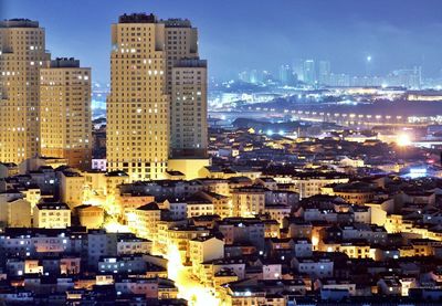 Illuminated cityscape against sky at night