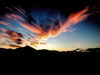 Scenic view of silhouette mountains against dramatic sky