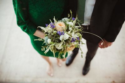 Midsection of couple holding flower bouquet