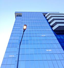 Low angle view of glass building against clear sky