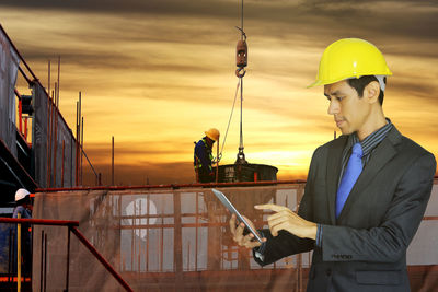 Man working on boat against sky