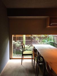 Man standing on table by window at home