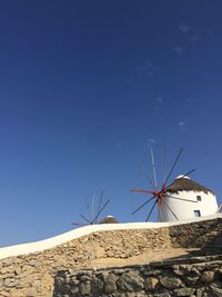 Low angle view of windmill against blue sky