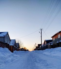 Houses on snow covered field against sky