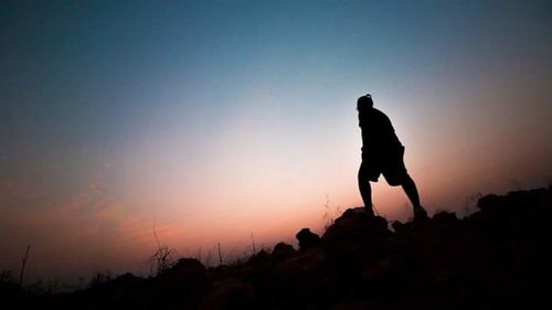 Silhouette of man standing against sky during sunset