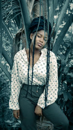 Portrait of young woman standing against bridge