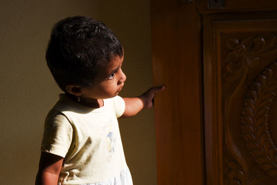 Cute girl looking away standing at home