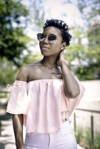 Young woman wearing sunglasses standing on field