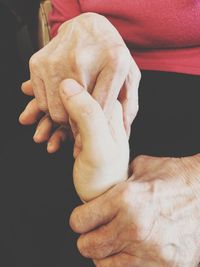 Close-up of man holding hands over white background