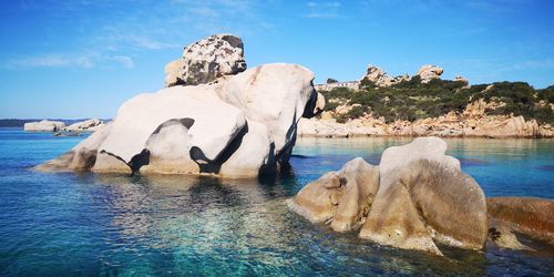 View of rock formation in sea against sky