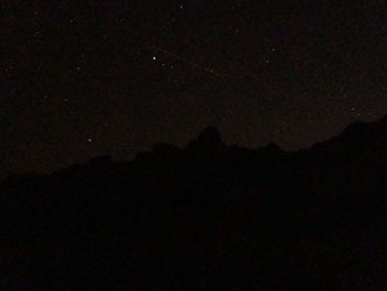 Low angle view of silhouette mountain against sky at night